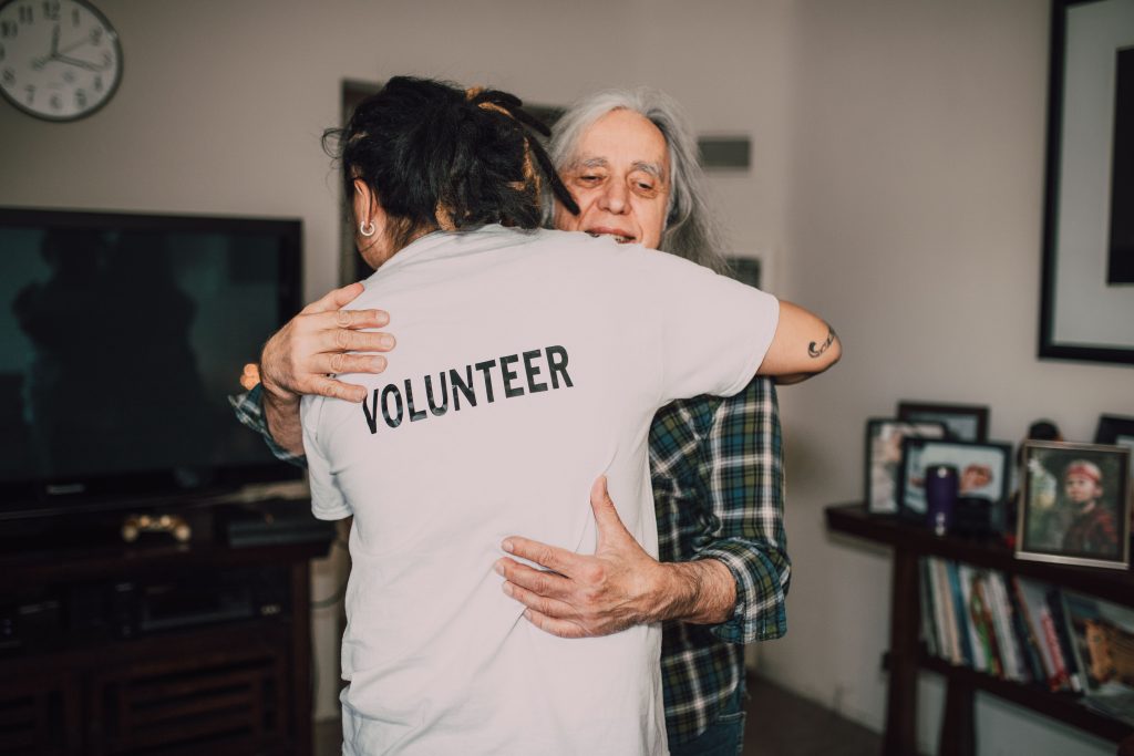 A volunteer helping an elderly person at home