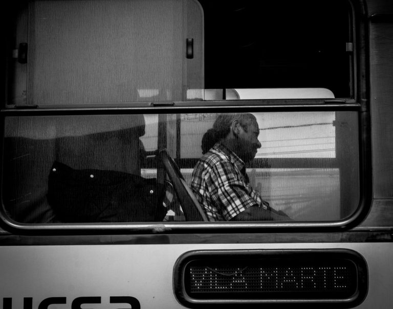 A passenger looking out through a train window, lost in thought