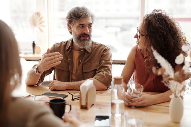A man and woman engaged in conversation at a cafe table