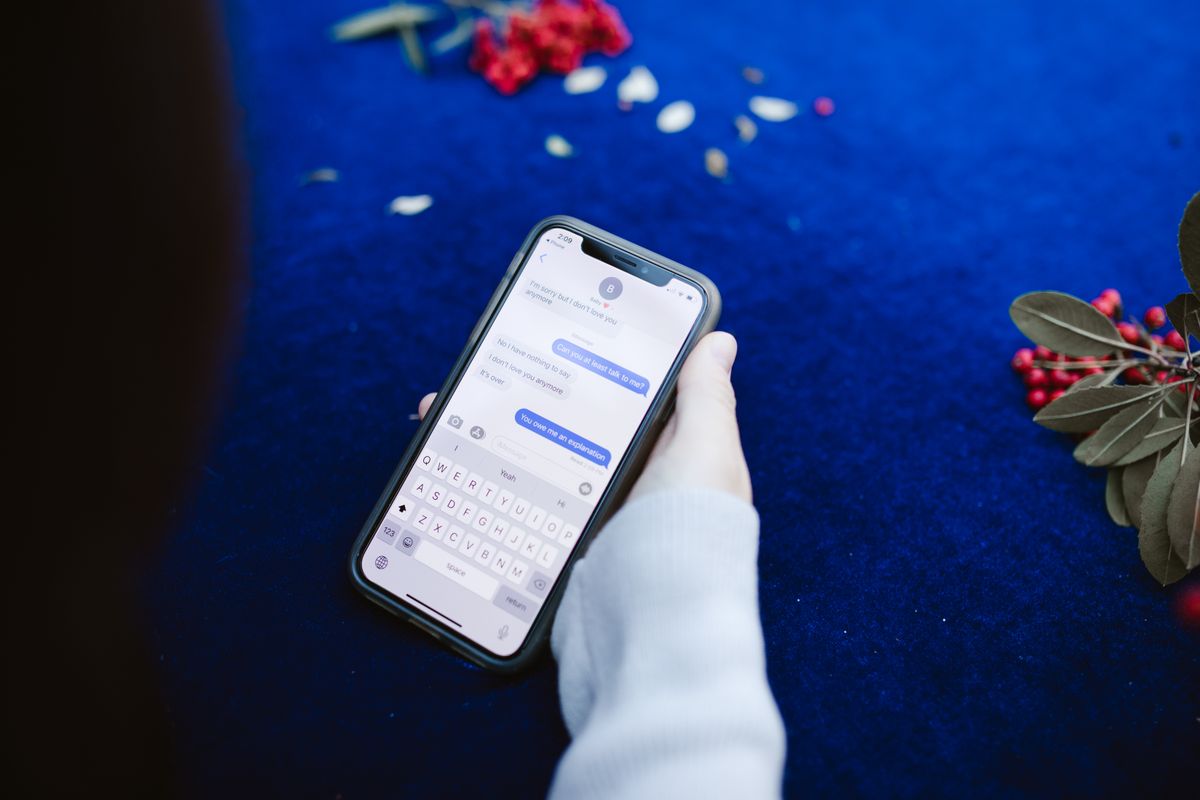 Close-up of a hand holding a phone showing a text message conversation