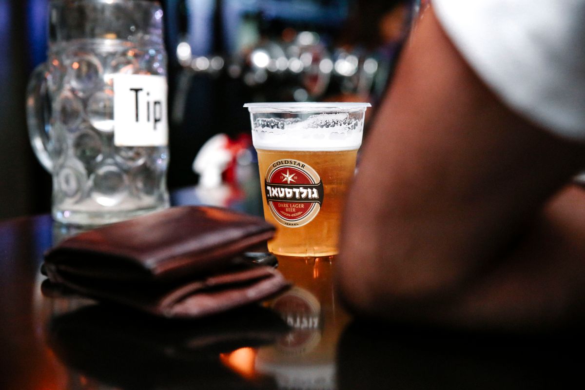 How Much Do You Tip a Robot? On the Moral Confusion of the Tipping Screen 2 A tip jar on a bar counter beside a glass of beer and a wallet