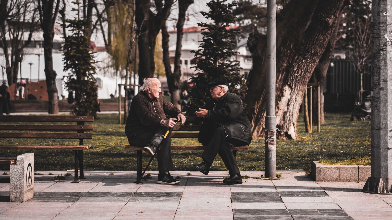 Two people sitting together on a public bench in a city