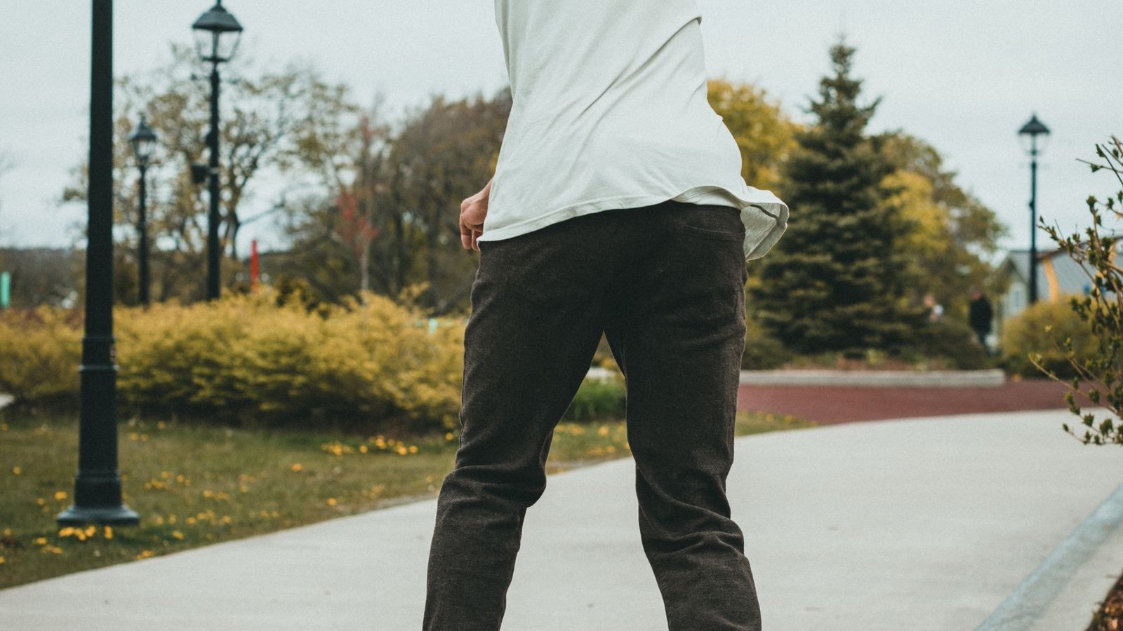A skateboarder using a concrete ledge in a city plaza, the kind of public surface that gets fitted with deterrents