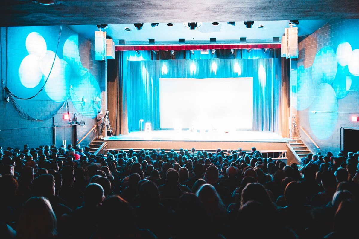 The Sound of Many Hands: On Applause and the Ethics of Approval 2 People sitting in theatre chairs during a performance