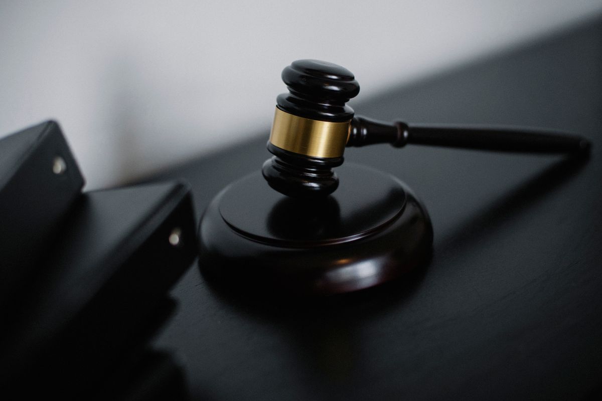 A wooden gavel resting on a courtroom desk, where a picture of pixels is asked to stand in for a record