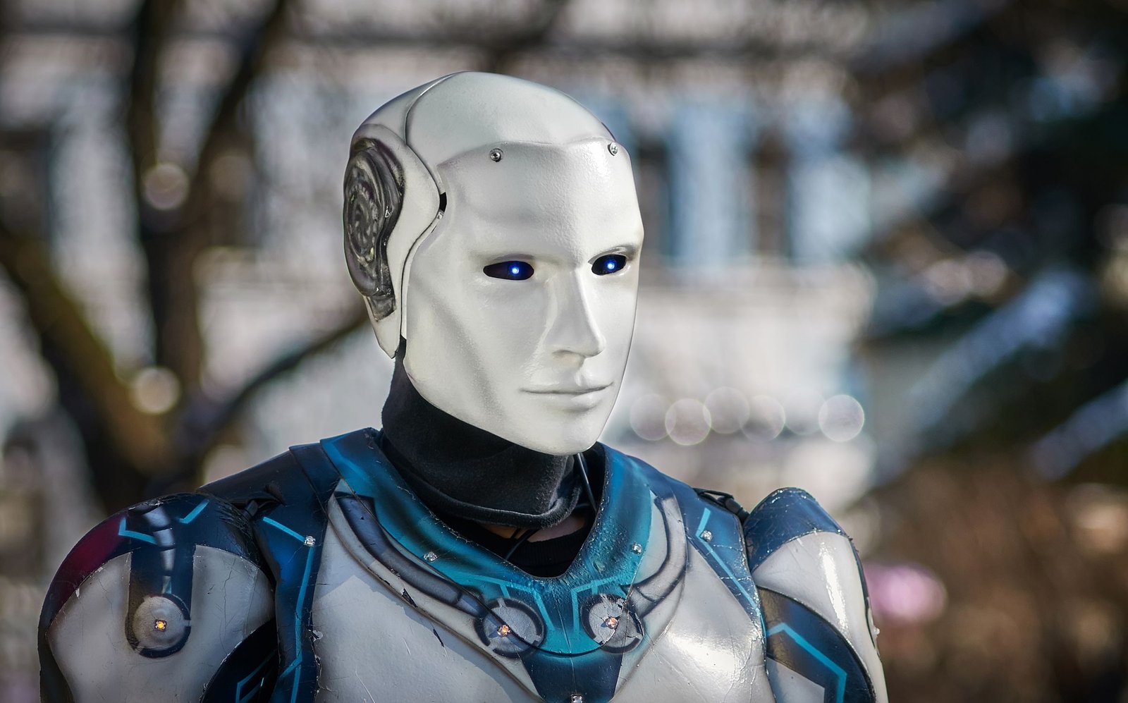 A humanoid robot with glowing eyes against a blurred city background