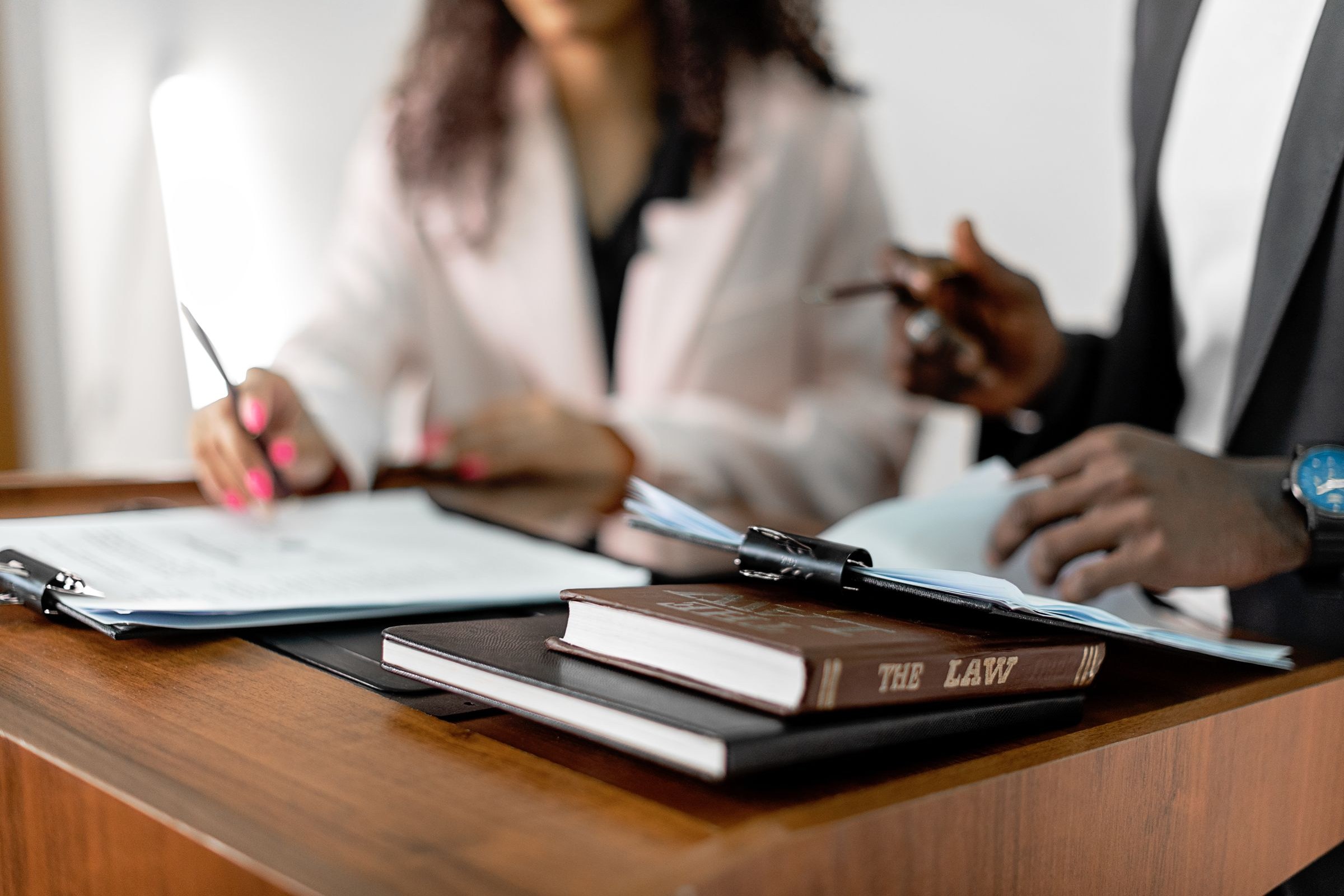 The House Can't Be Split: On Inheritance and the Ethics of Who Gets What 3 Two lawyers reviewing documents with law books on a desk