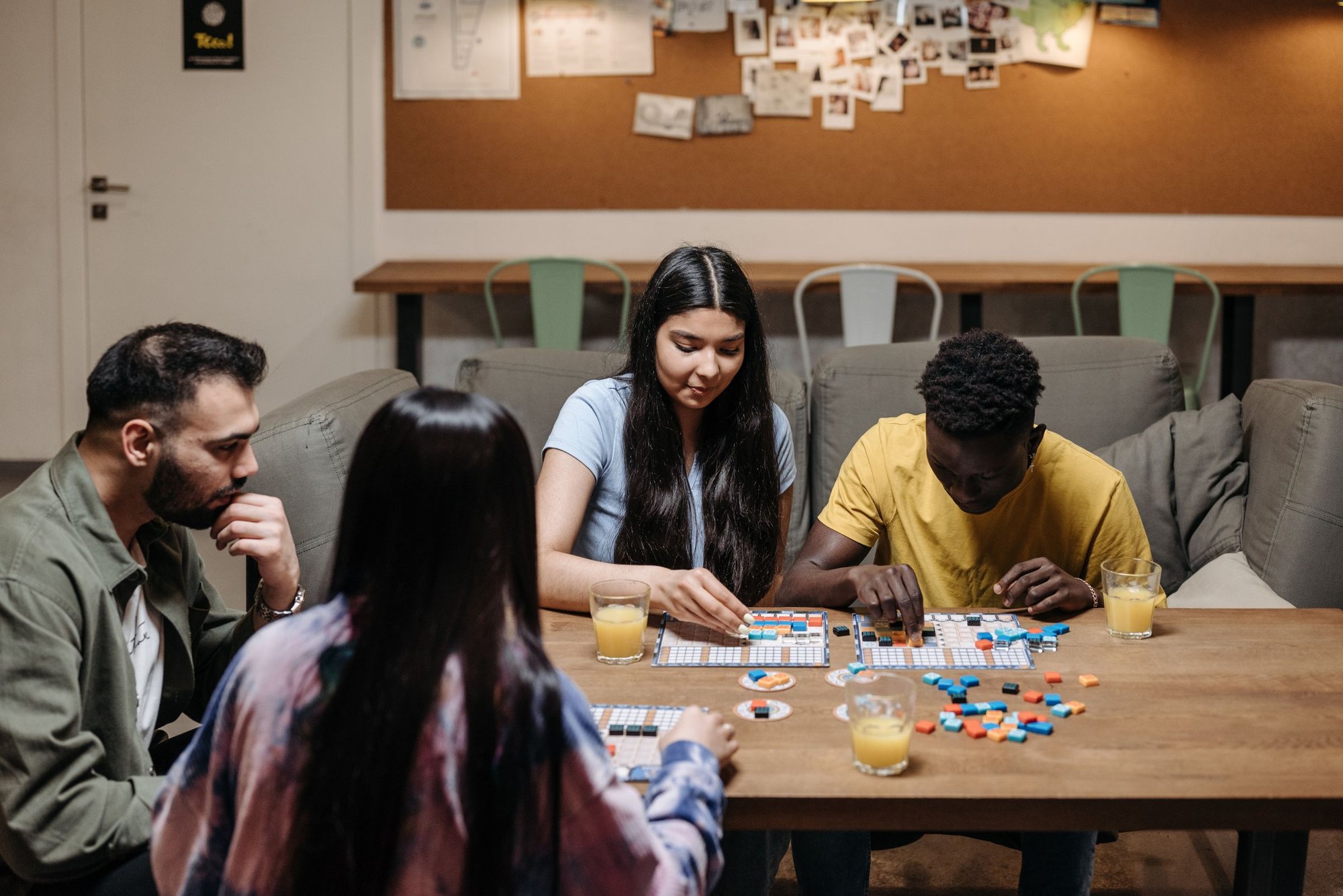A group of friends gathered around a table playing a board game together