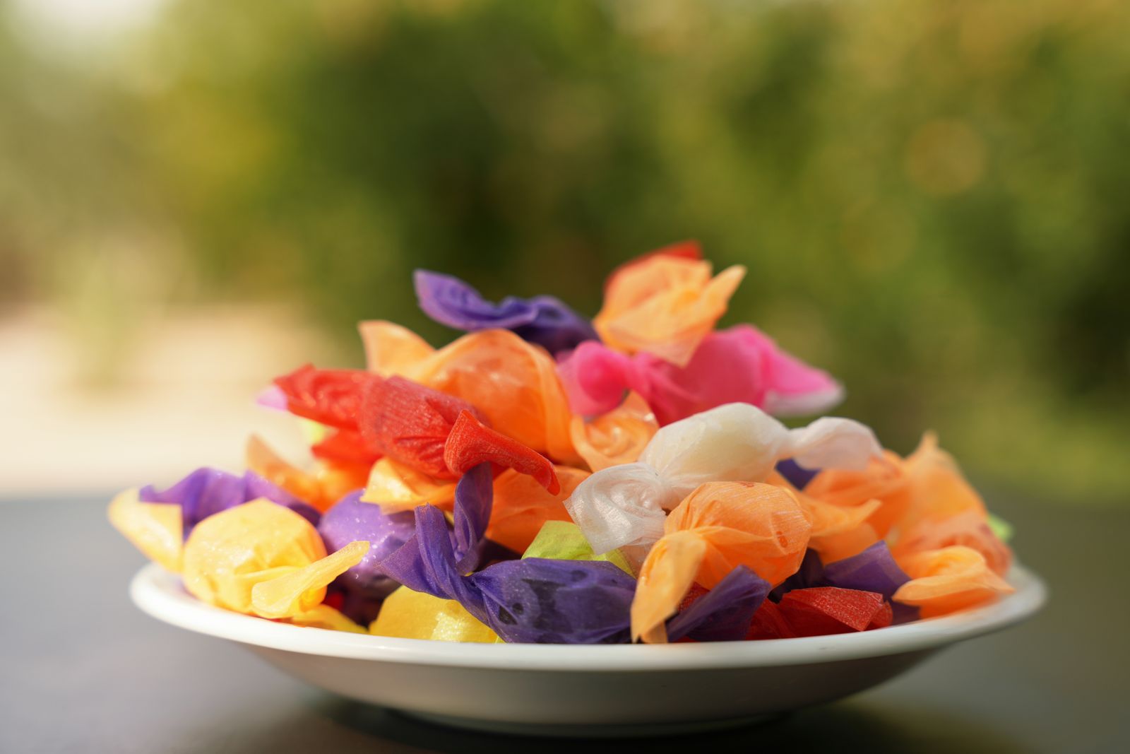A white bowl filled with wrapped candies