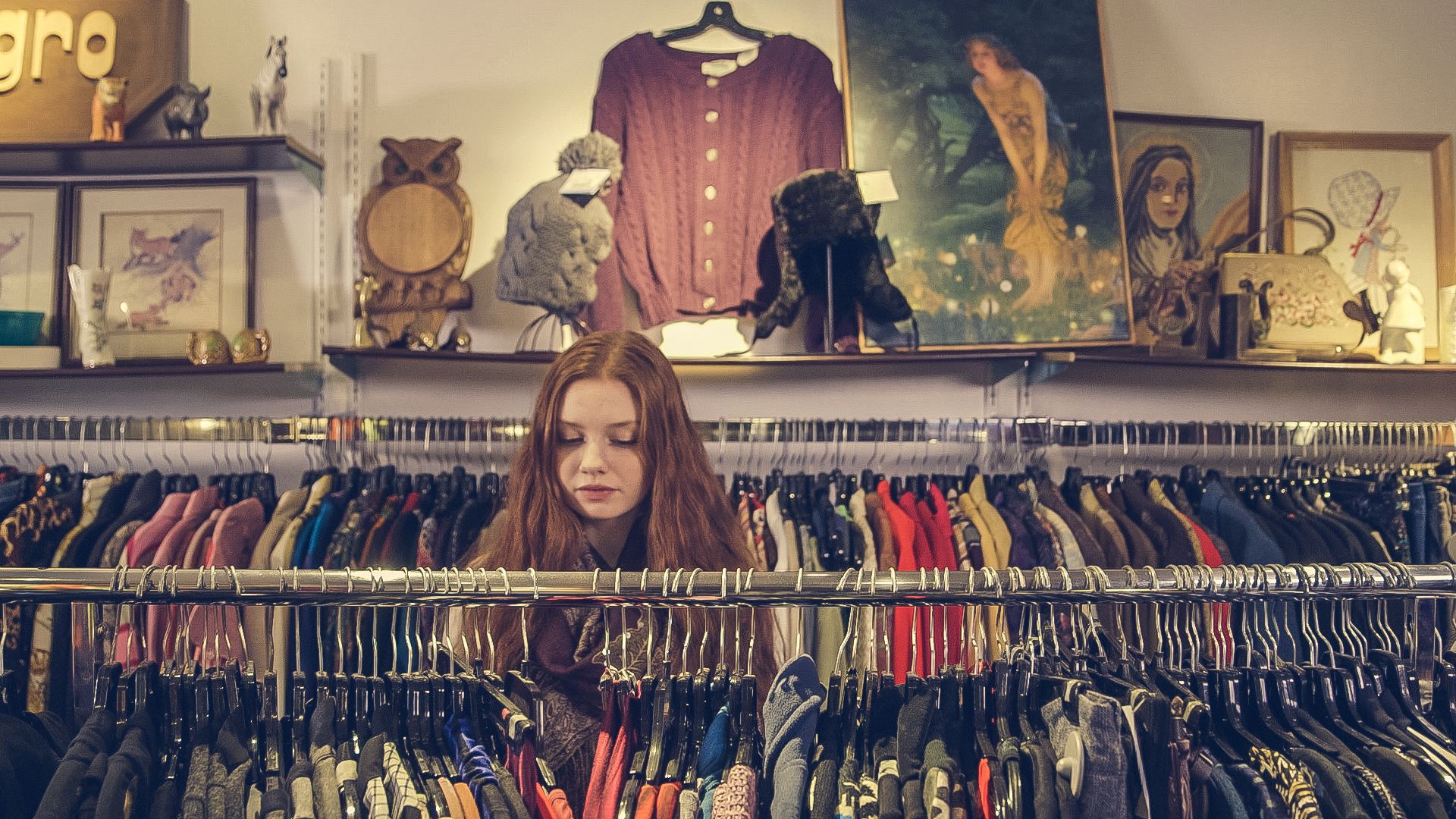 The Bag by the Door: On Donations, Guilt, and Where Your Clothes Actually Go 3 A shopper browsing racks of secondhand clothing in a crowded vintage shop