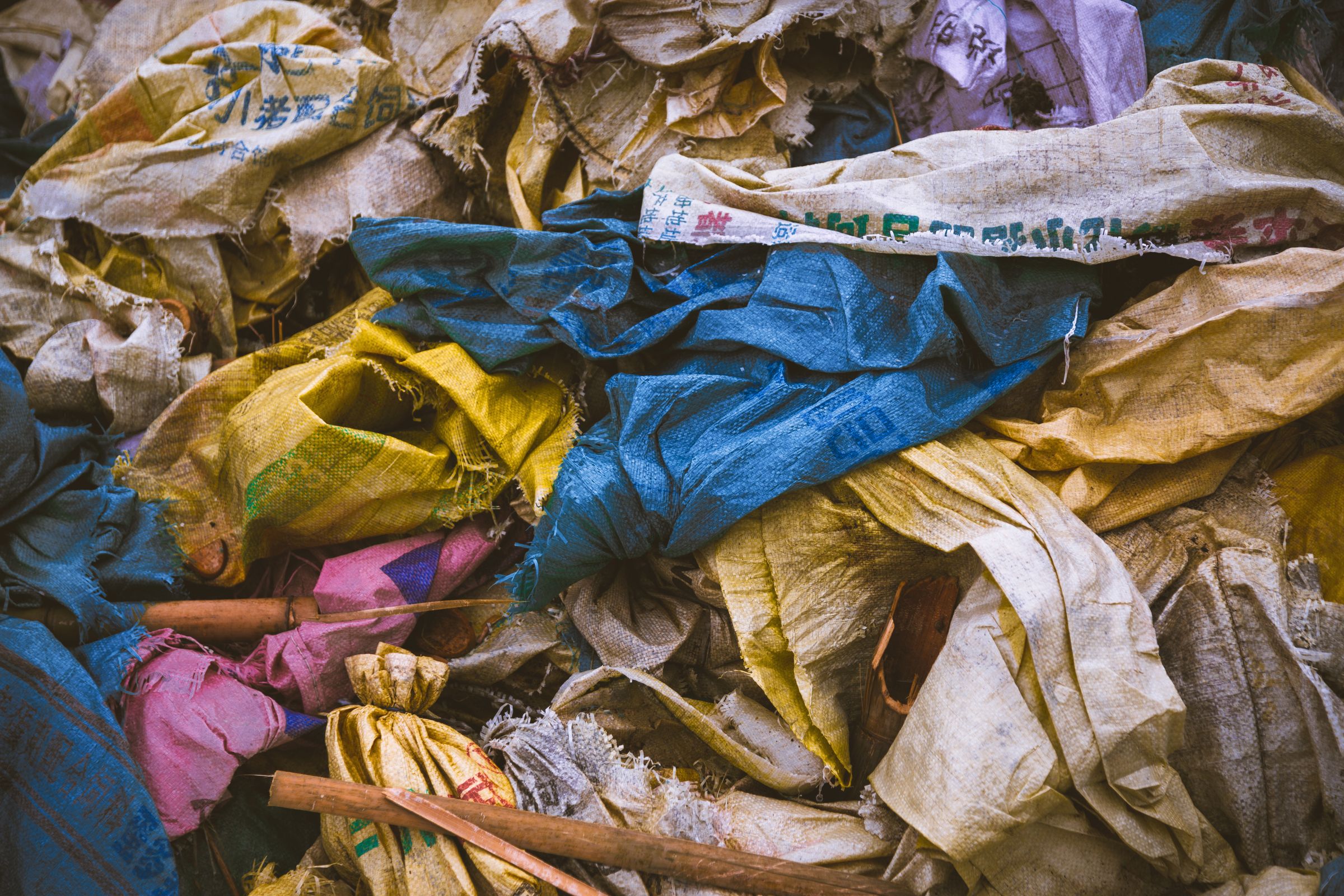 The Bag by the Door: On Donations, Guilt, and Where Your Clothes Actually Go 4 Piled bags of discarded clothing waiting to be moved on